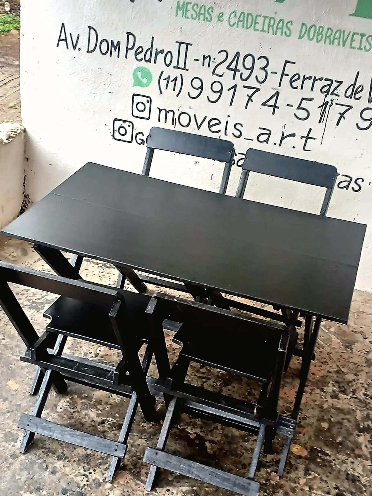 Mesa dobrável preta com cadeiras em produção real da A.R.T Móveis